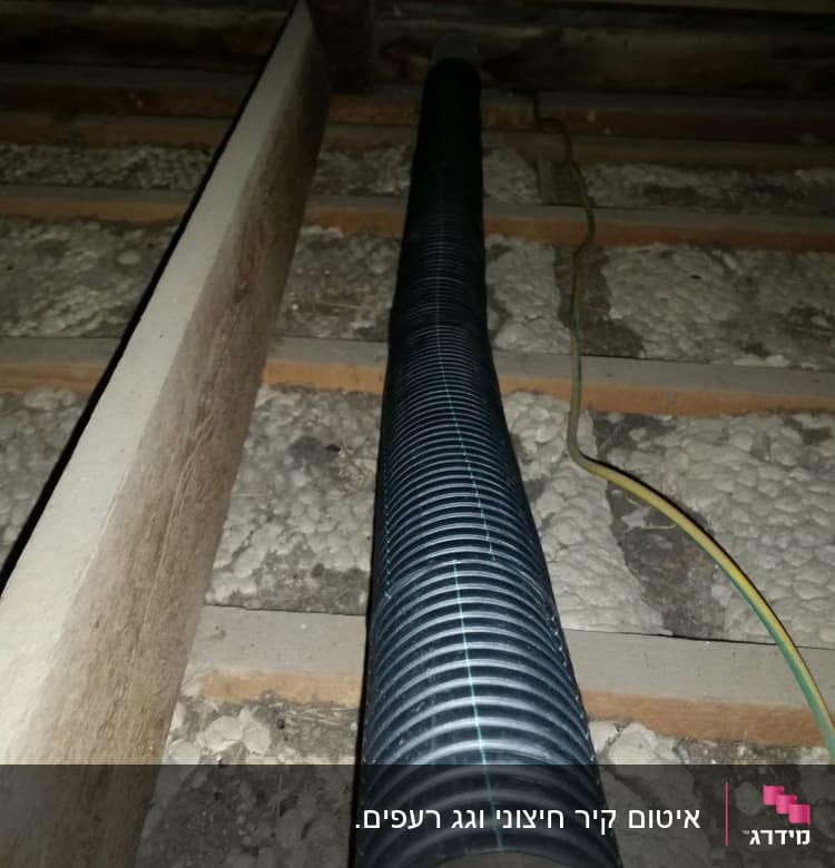 צינור גמיש מתחת לגג רעפים עם קורות עץ